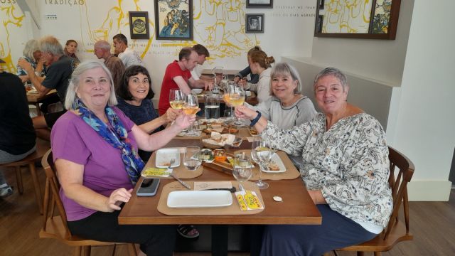 A lively group enjoying wine at a table during a small-group Portuguese food tour in Lisbon.