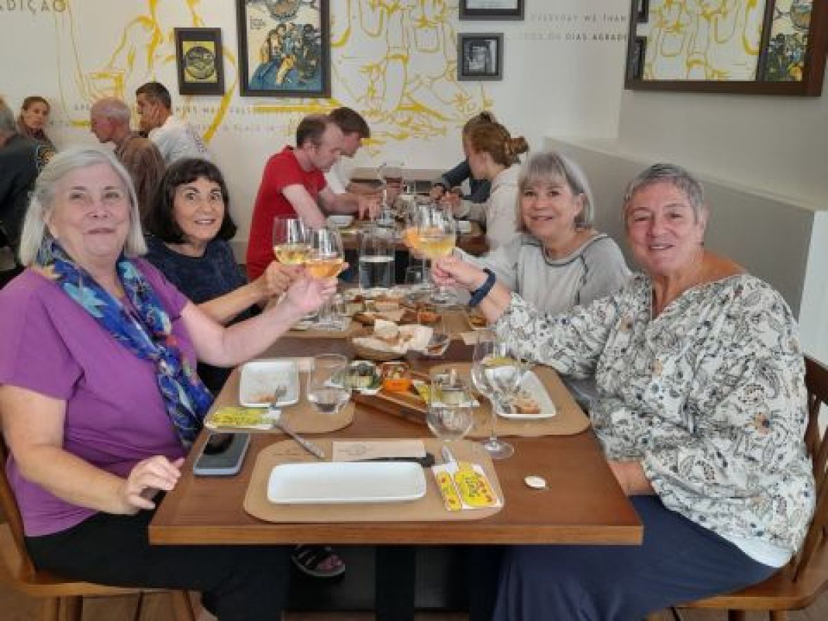 A lively group enjoying wine at a table during a small-group Portuguese food tour in Lisbon.