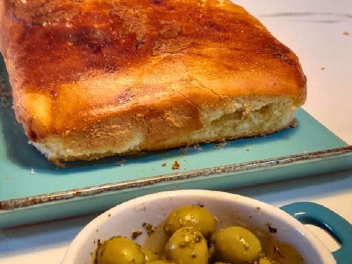 A beautiful loaf of bread on a blue plate with olives, created in our delightful cooking class in Portugal