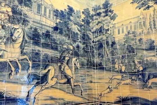 A mural depicting horses and people in a palace, complemented by Portuguese tiles appreciated by a small tour group.