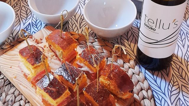 Chorizo bread served on a plate with a bottle of Douro wine beside it.