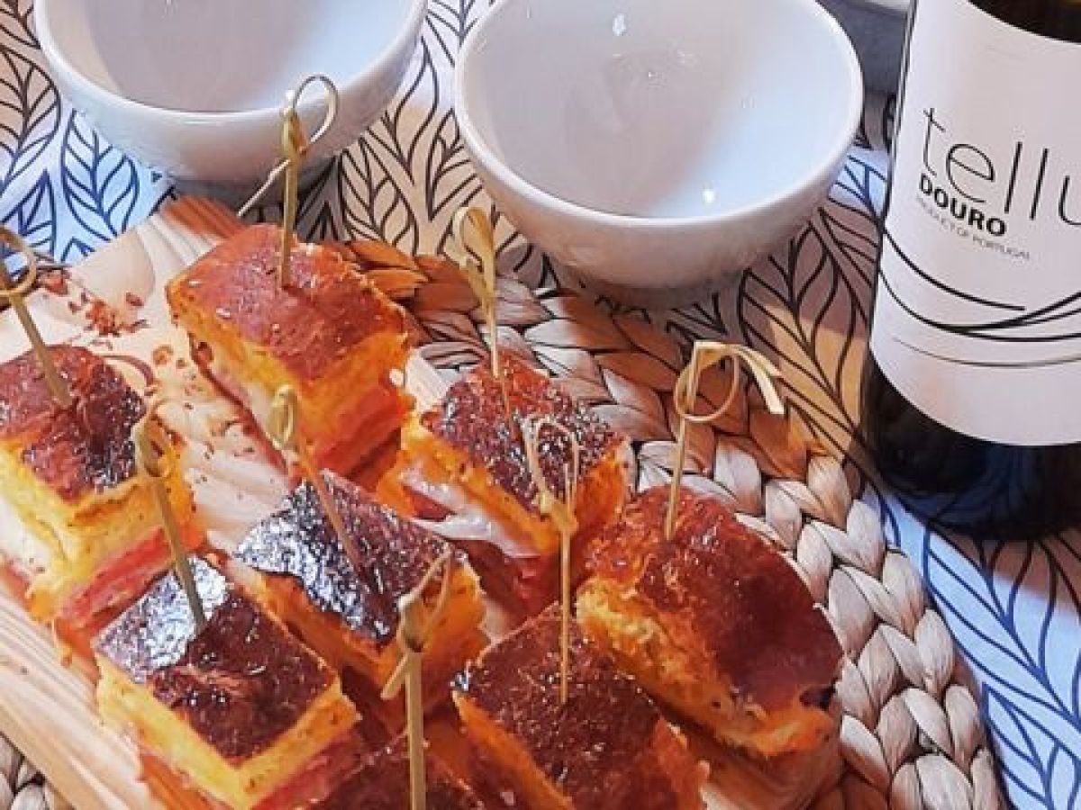 Chorizo bread served on a plate with a bottle of Douro wine beside it.