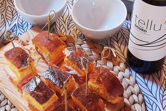 Chorizo bread served on a plate with a bottle of Douro wine beside it.