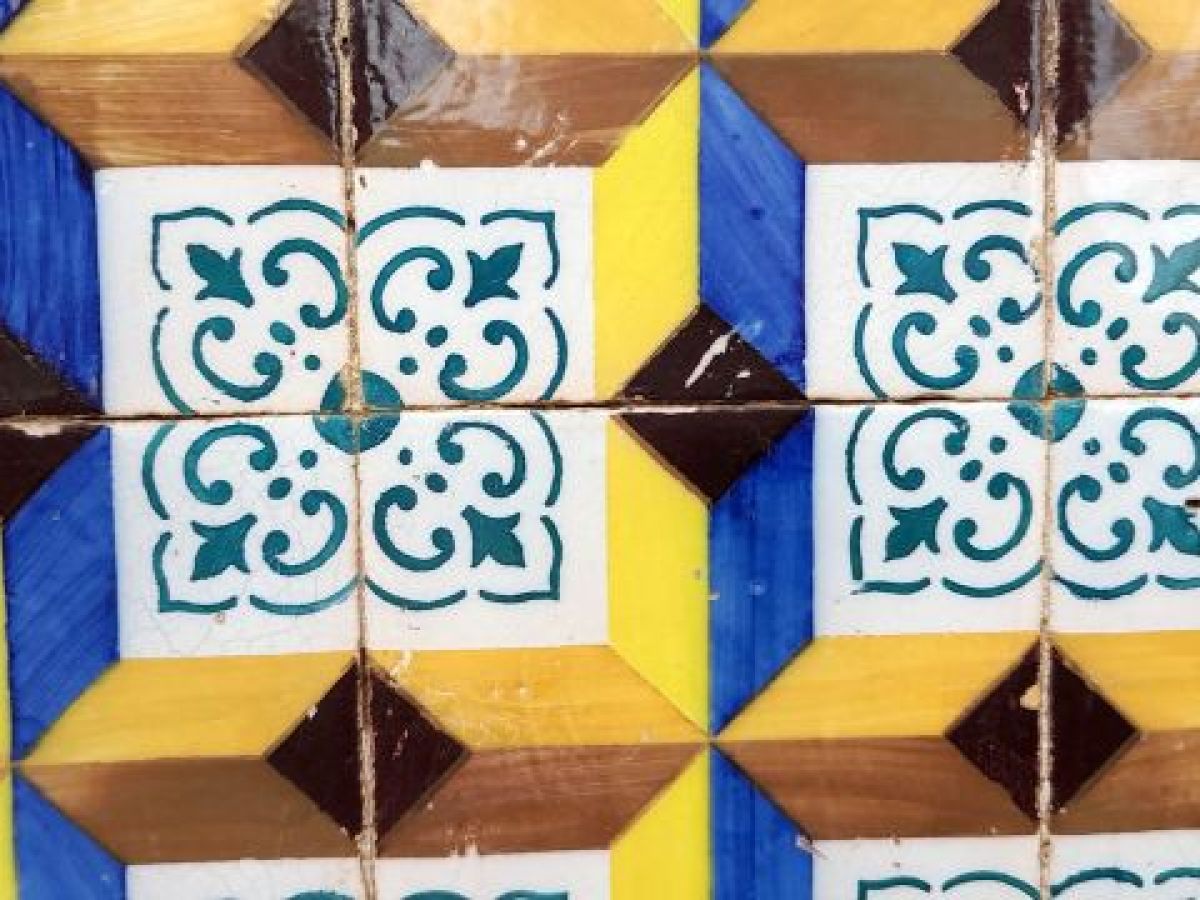 Colorful modern tiles create a striking wall in Lisbon, captured in a close-up view highlighting their intricate details.