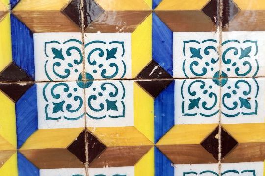 Colorful modern tiles create a striking wall in Lisbon, captured in a close-up view highlighting their intricate details.