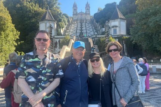 A group of four stands smiling in front of the Bom Jesus sanctuary, captured during their private tour in Braga.