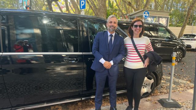 A man and woman stand beside a black luxury van, ready for their private tour.