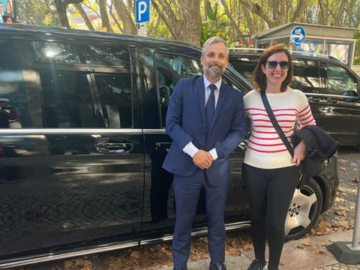 A man and woman stand beside a black luxury van, ready for their private tour.