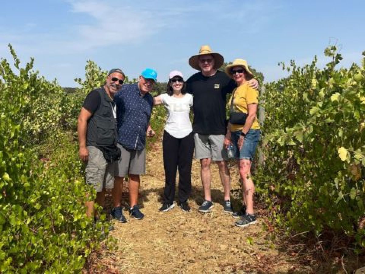 Friends posing for a photo in a vineyard during a private cork tour in Évora, Portugal, celebrating wine production.
