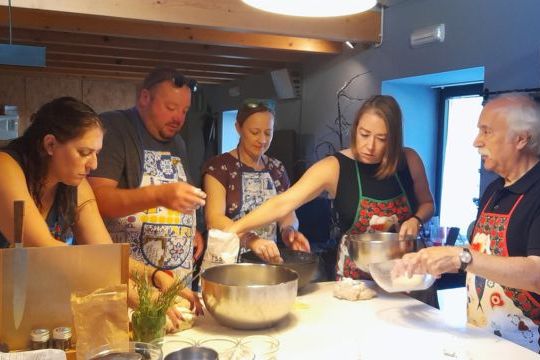 A group of participants kneading dough during a bread-making class in Portugal, focused on their culinary task.